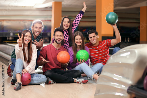 Group of friends with balls in bowling club