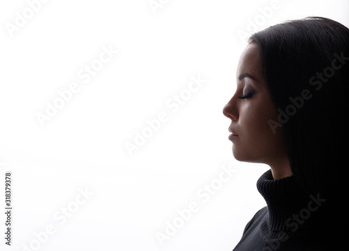 Portrait of woman with closed eyes on white background. Young female in profile. Free space for text.