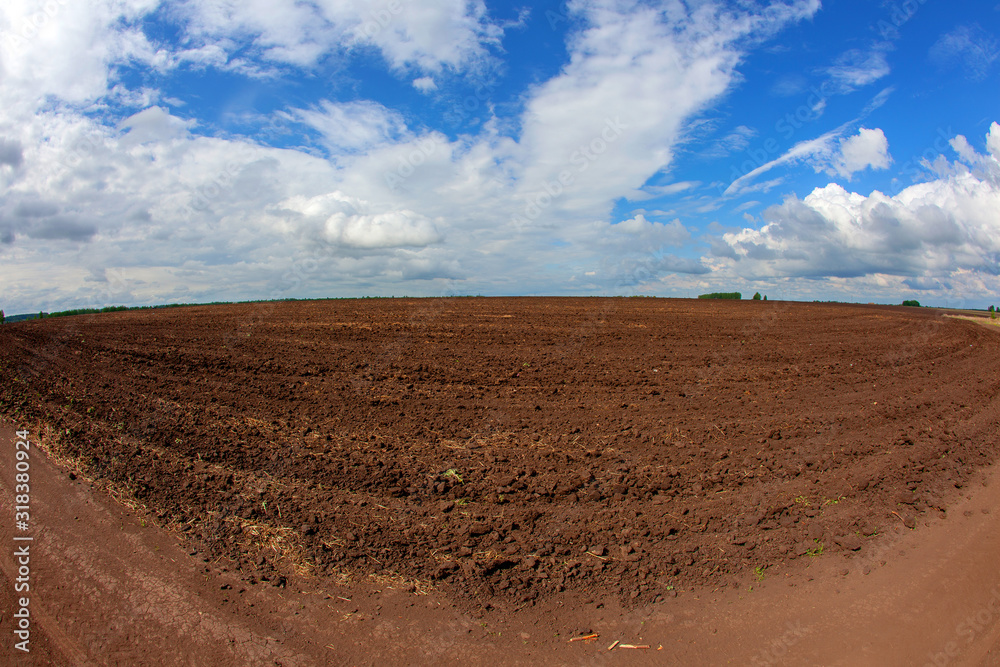 Agricultural fields are plowed for sowing. Spring sunny day. White clouds on a blue sky. Agricultural fields are plowed for sowing. Spring sunny day. White clouds on a blue sky.
