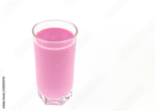 Close-up of pink fruit milk yogurt in a transparent glass of a glass for design on a white background
