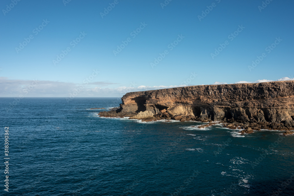 Cliffs by the ocean under blue sky. Ajuy, Fuerteventura. 