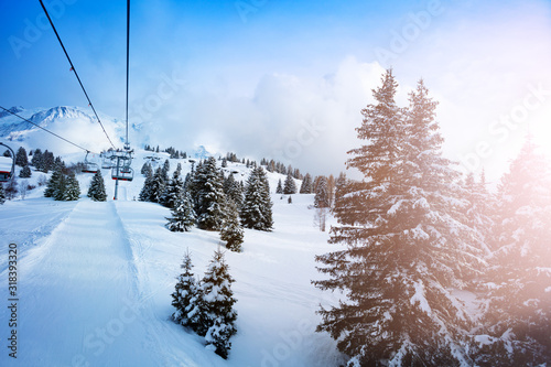 Ski lift in snow alps mountain with firs on sunny winter day Mont-Blanc, Chamonix region, France
