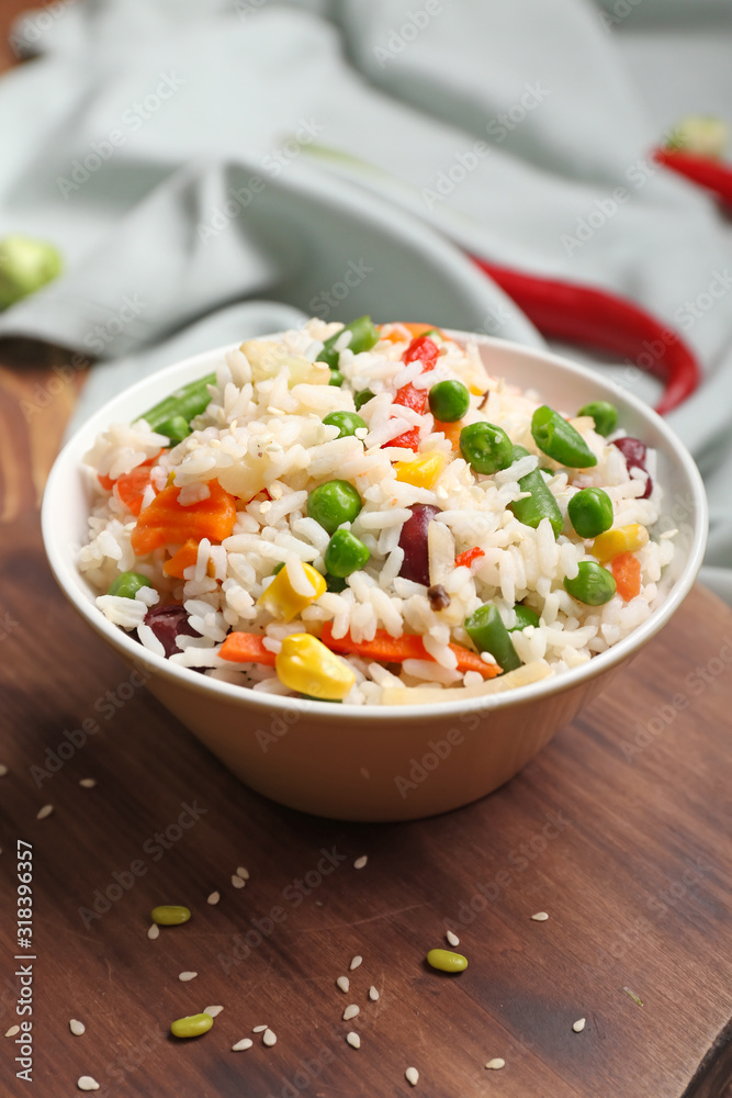 Bowl with boiled rice and vegetables on table Bowl with boiled rice and vegetables on table
