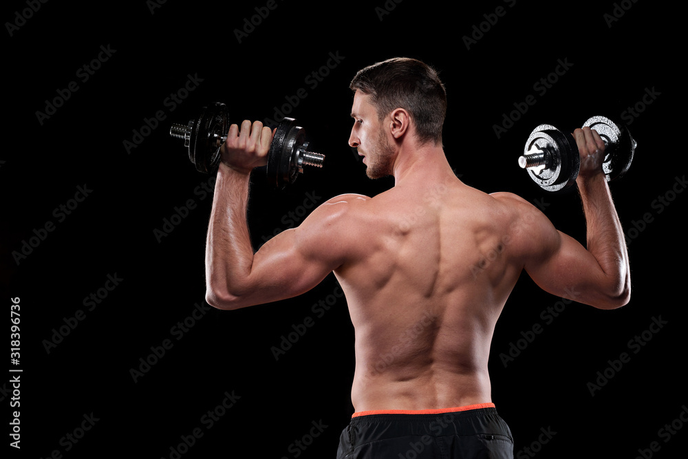 Rear view of young muscular shirtless sportsman exercising with dumbbells Rear view of young muscular shirtless sportsman exercising with dumbbells