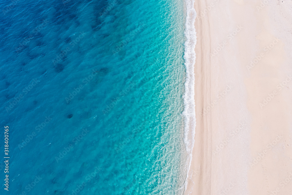 Top-down aerial view of a white sandy beach on the shores of a beautiful turquoise sea. - obrazy, fototapety, plakaty 