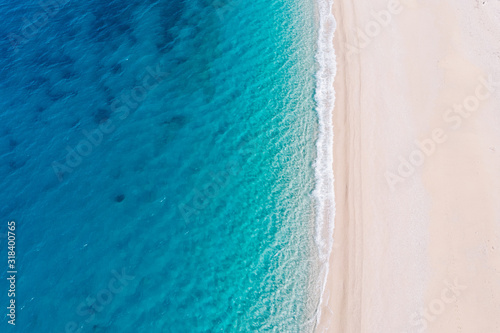 Top-down aerial view of a white sandy beach on the shores of a beautiful turquoise sea. photo