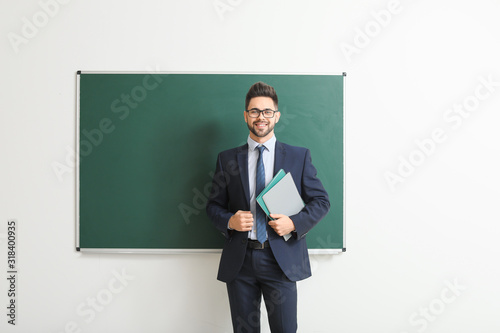 Male teacher near blackboar...