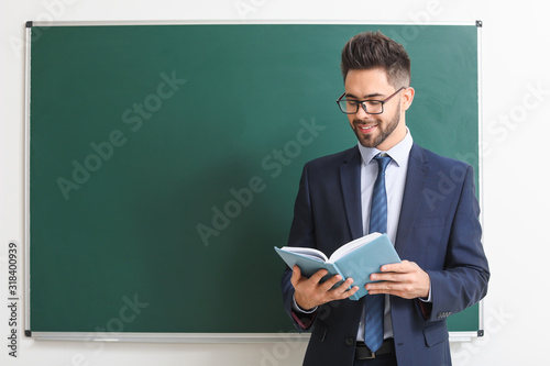 Male teacher near blackboar...