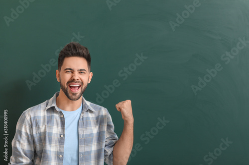 Happy teacher near blackboa...