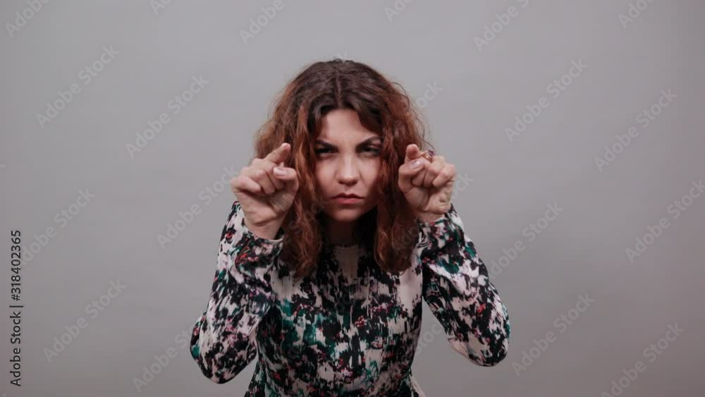 Unhappy charming young lady over isolated gray background in fashion shirt pointing fingers at camera, looking angry, having nice ring. People emotions. Lifestyle concept Unhappy charming young lady over isolated gray background in fashion shirt pointing fingers at camera, looking angry, having nice ring. People emotions. Lifestyle concept