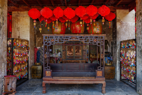 Front view of shrine of Buddhism Chinese temple decorated with ema and red lanterns at Lhong 1919, former warehouse is located on riverside of Chao Phraya River.