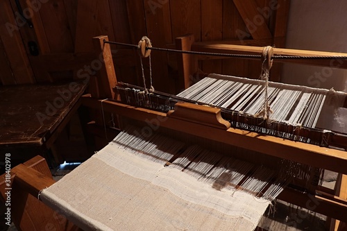 Mechanical wooden vintage hand-loom used for cloth making, mostly from flax, with example of white cloth in production. photo