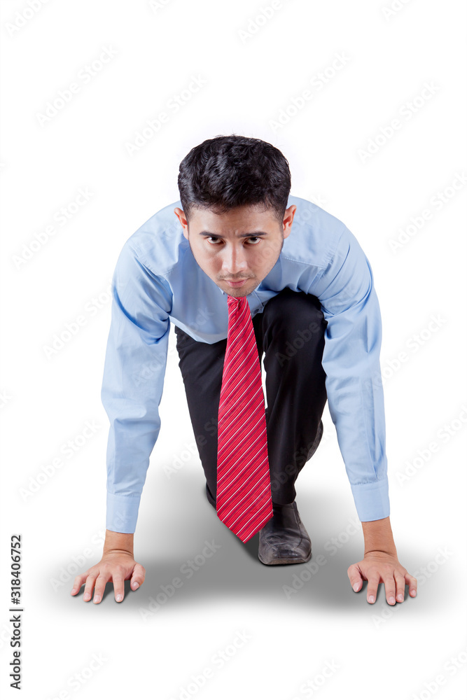 Businessman in ready position to run Businessman in ready position to run