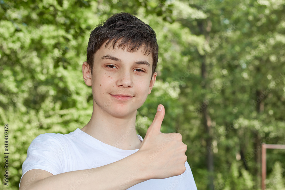 teenager showing thumbs up on background of nature teenager showing thumbs up on background of nature