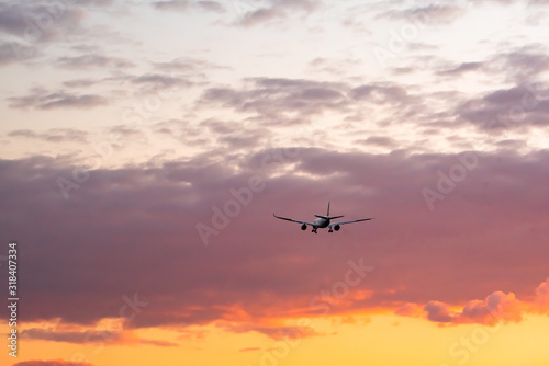 Travel background landing plane silhouette on a vivid sunset sky space for text clouds