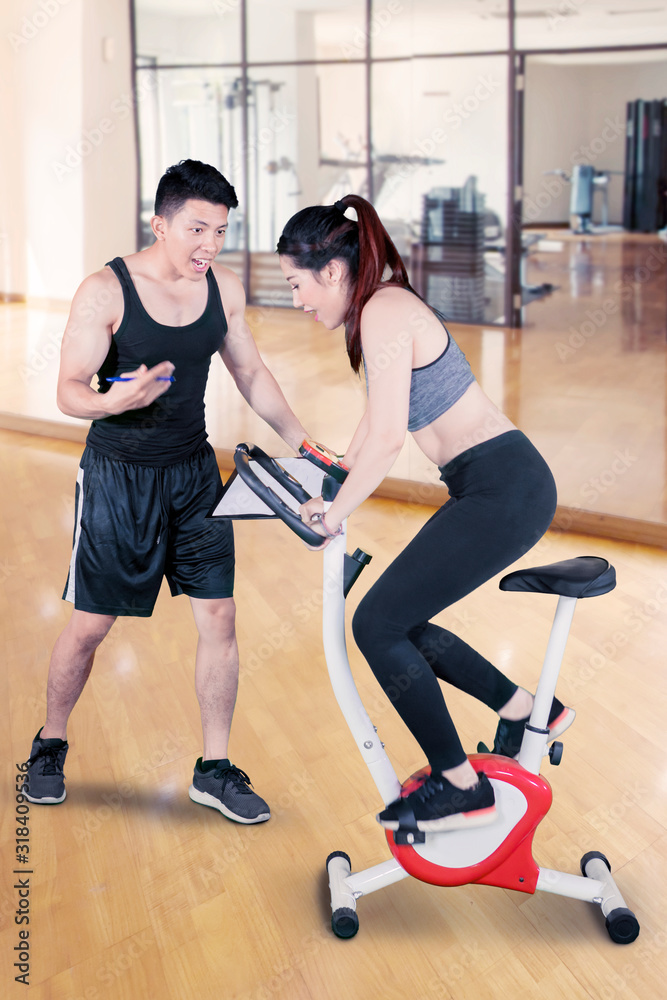 Woman riding a spinning exercise bike at gym Woman riding a spinning exercise bike at gym
