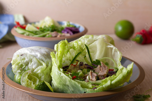 Stuffed iceberg lettuce leaves with turkey and vegetables on blue plate. Healthy diet food