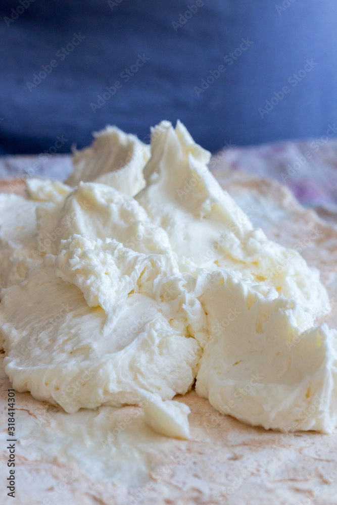 white cream lies in a heap (mass) on a white cake on a dark blue (blue) background