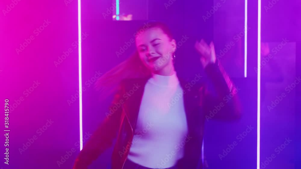 Neon woman. Disco party. Teen girl having fun enjoying dancing in nightclub purple illumination. Neon woman. Disco party. Teen girl having fun enjoying dancing in nightclub purple illumination.