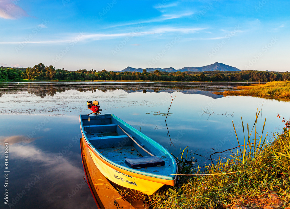 Obraz premium Boat in river sunset or sunrise with colr of cloud sky