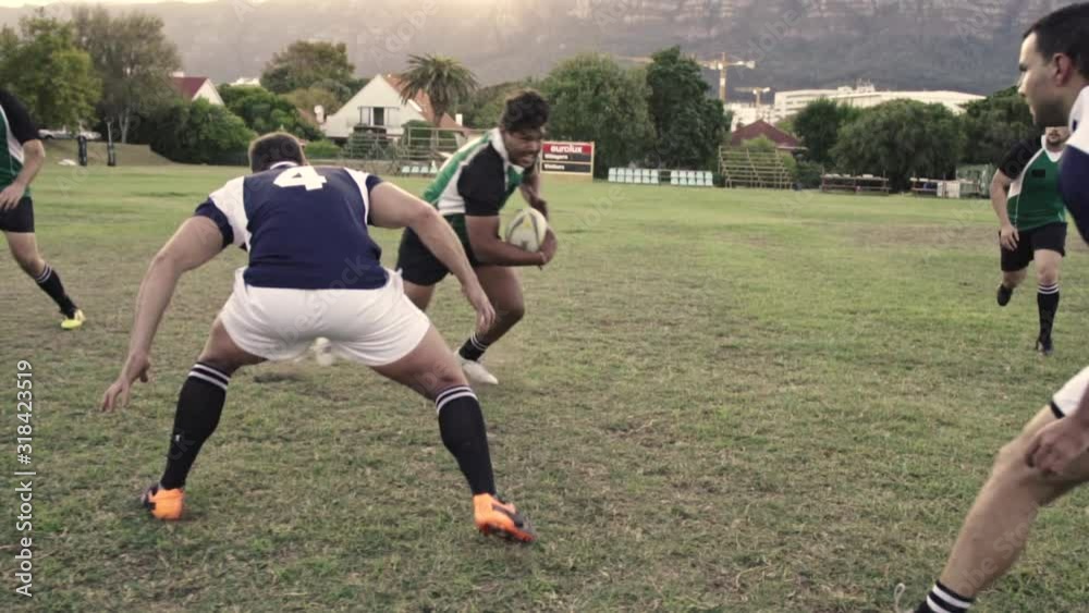 Rugby player displaying his skills of tackling with the opponent during the match. Strong young men playing a game of rugby on the field. Rugby player displaying his skills of tackling with the opponent during the match. Strong young men playing a game of rugby on the field.