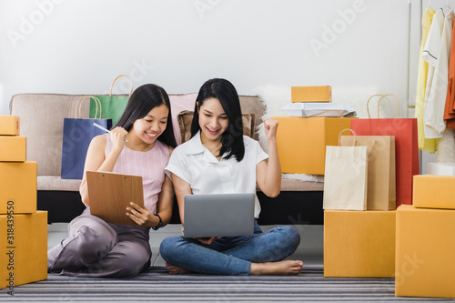 Asian beautiful empower woman and friend working with online business shop at home.Owner businesswoman start up with Accept orders,Check number of products,Prepare to deliver products to customers.