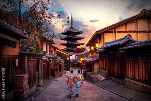 Two geishas wearing traditional japanese kimono among at Yasaka Pagoda and Sannen Zaka Street in Kyoto, Japan. photo