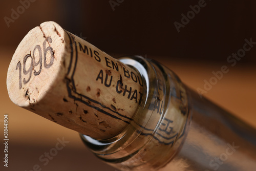Closeup of a wine cork and the neck of a wine bottle. Mis en Bouteille au Chatueau translates to Bottled at the Chateau.