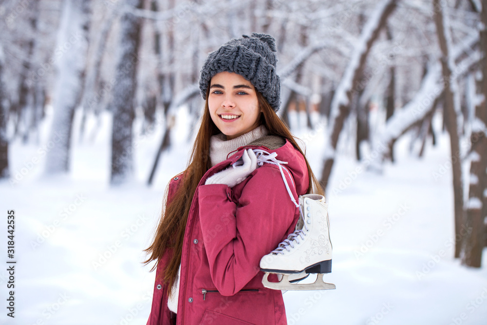Happy beautiful brunette woman with ice skates go to the rink, winter outdoors Happy beautiful brunette woman with ice skates go to the rink, winter outdoors