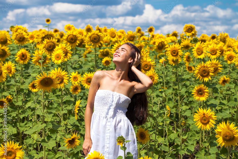 Portrait of a young beautiful girl in a field of sunflowers