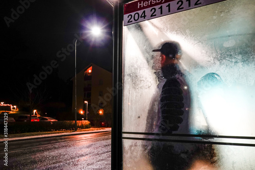 Canvas Print Stockholm, Sweden A man stands at a frosty bus stop in the suburbs