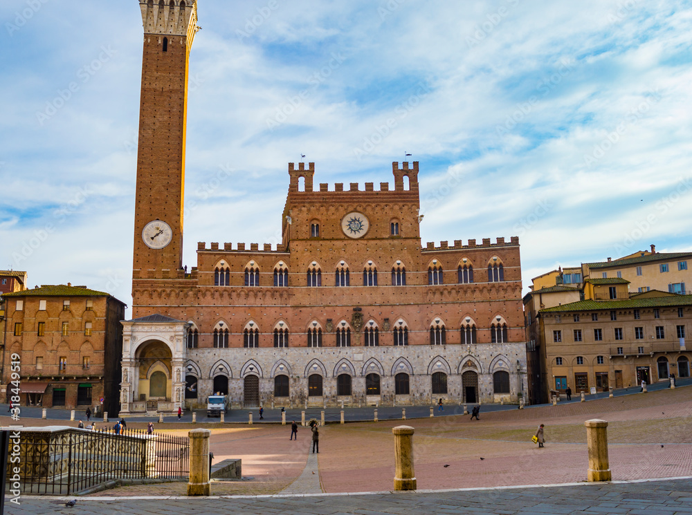 Siena, Italy - CIRCA 2013: Piazza del Campo with several tourists visible. Torre del Mangia and Town Hall are also visible in the background.