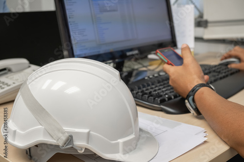 The white industrial helmet is placed in the office and worker background