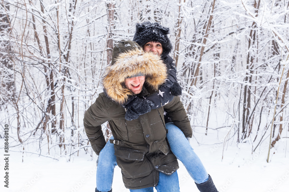 Portrait of happy young couple in winter park with their friend behind Portrait of happy young couple in winter park with their friend behind