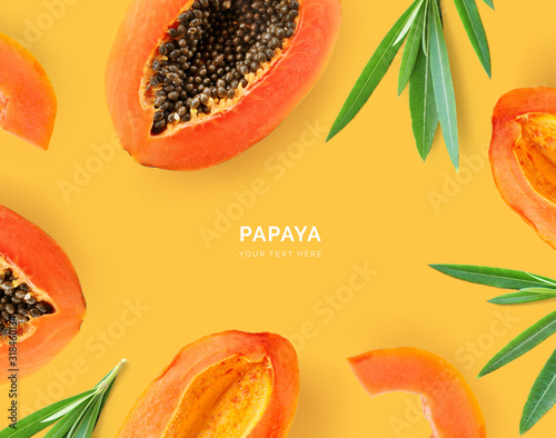 Creative layout made of papaya and leaves. Flat lay. Food concept. Papaya on yellow background.