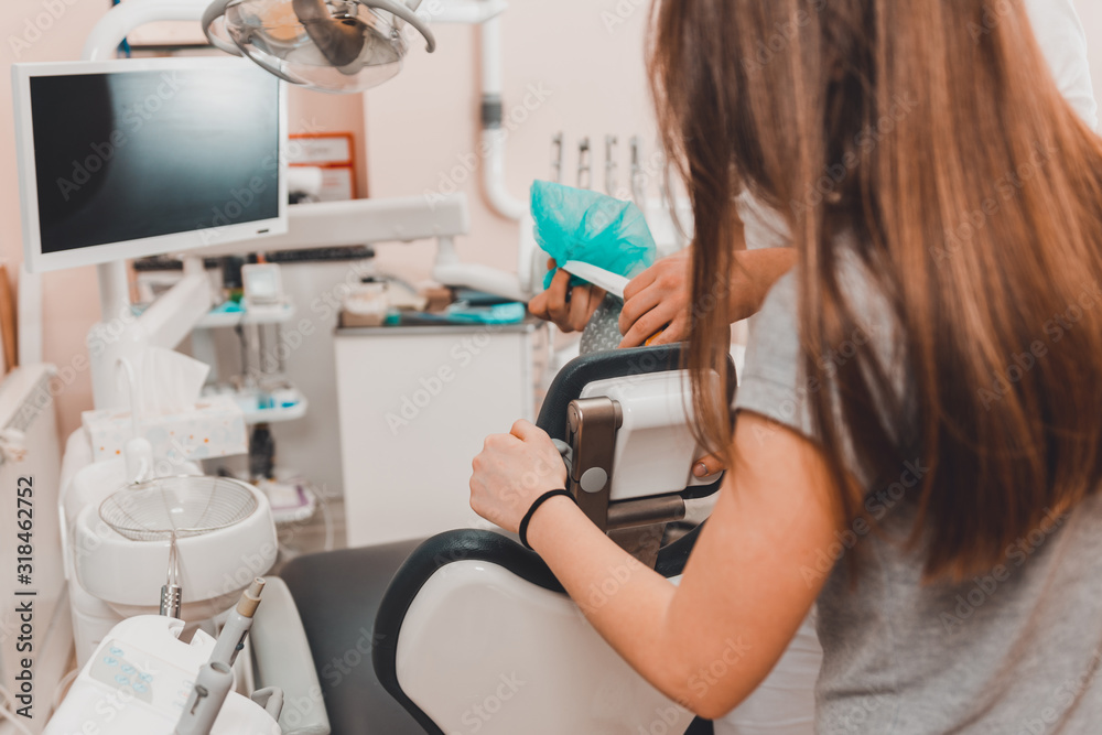 Dentist woman removes dental chair after procedures.