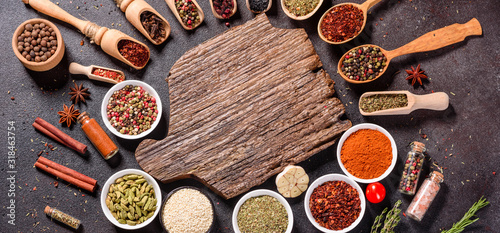 Spices and herbs over black stone background. Top view with free space for menu or recipes