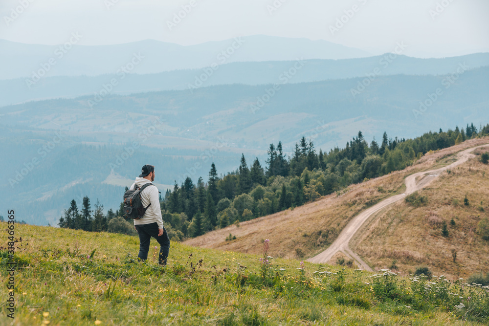 man with backpack hiking in mountains