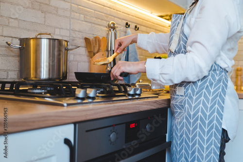 woman fry on pan kitchen view