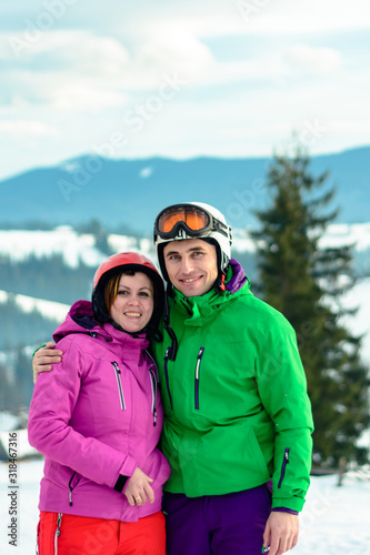 Happy young couple relaxing in winter in mountains.