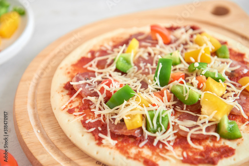 Raw pizza dough with tomato sauce, ingredients