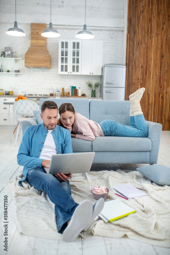Happy dad and daughter looking at laptop at home. Happy dad and daughter looking at laptop at home.