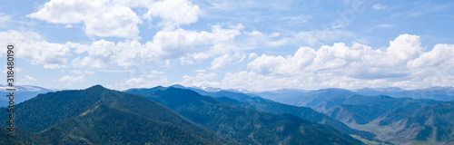 Aerial panoramic wide banner view of a Chike-Taman pass in the Altai mountains with green trees, Blue sky and clouds.