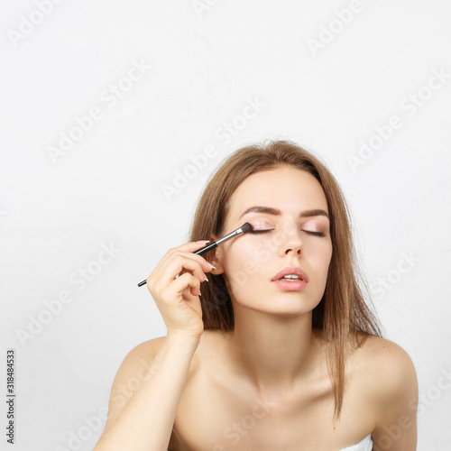Beautiful woman in a towel making makeup