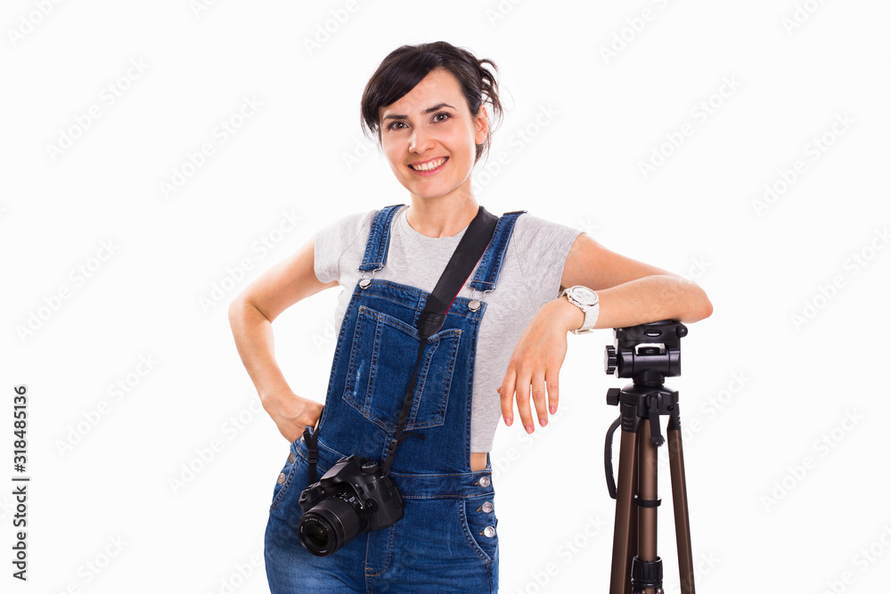 Young beautiful girl in jeans overalls with a camera on a white isolated background Young beautiful girl in jeans overalls with a camera on a white isolated background