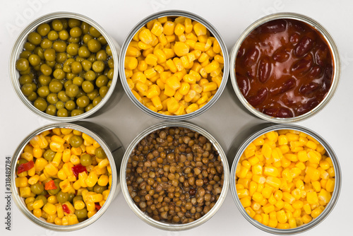 Canned food on white background. Green pea, beans, corn, lentils.