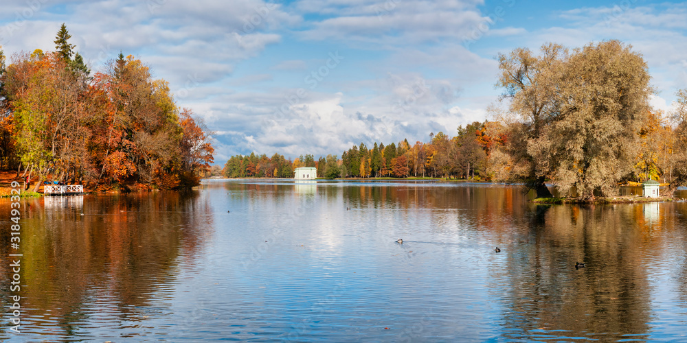 Panorama of beautiful autumn park with pond on clear day Panorama of beautiful autumn park with pond on clear day