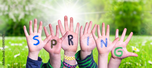 Children Hands Building Colorful Word Spring. Green Grass Meadow As Background