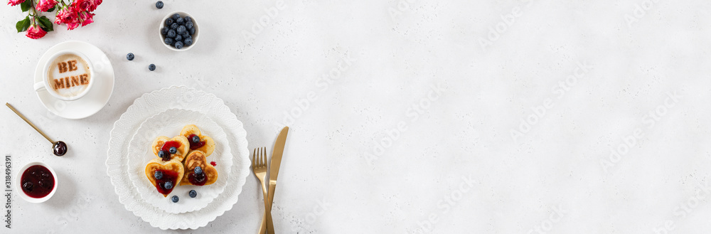 Heart shaped pancakes and a cup of coffee on a white background. Festive breakfast for Valentine's Day, sweet valentine. Cafe, restaurant menu banner. Copy space Heart shaped pancakes and a cup of coffee on a white background. Festive breakfast for Valentine's Day, sweet valentine. Cafe, restaurant menu banner. Copy space