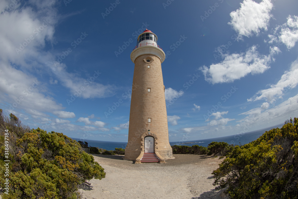 Fisheye view at a lighthouse with a blue sky and clouds on the background